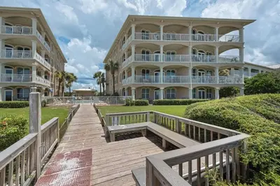 a boardwalk leading to a large apartment building at Monterey C-201 in Seacrest