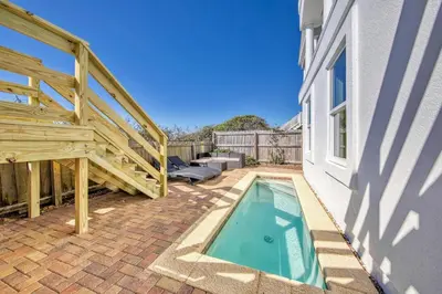 a small swimming pool next to a house with a staircase at Ocean Front Property in Seacrest