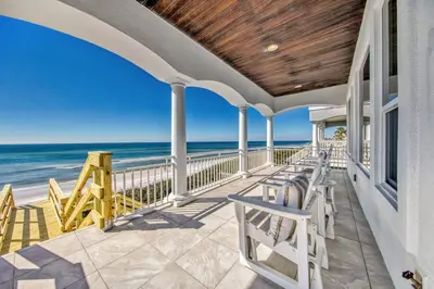 a porch with chairs and the ocean in the background at Ocean Front Property in Seacrest
