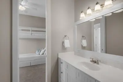 a white bathroom with a sink and a mirror at Wine Down 30A in Seacrest