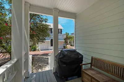 a porch with a trash can and a bench at Wine Down 30A in Seacrest