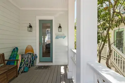 a porch with a blue door on a house at Wine Down 30A in Seacrest