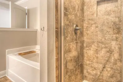a shower with a glass door with a tub at Here & Now in Inlet Beach