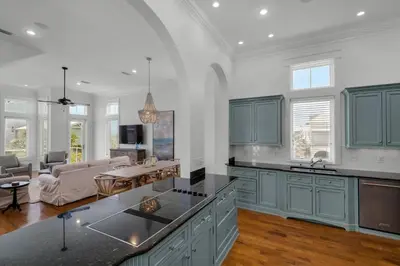a kitchen with blue cabinets and a living room at Scout's Lookout in Inlet Beach