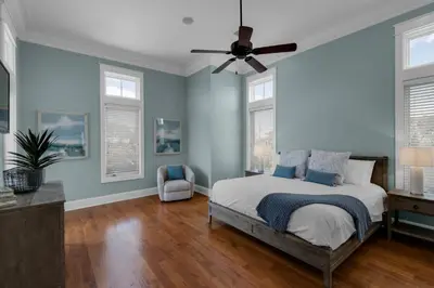 a bedroom with blue walls and a ceiling fan at Scout's Lookout in Inlet Beach