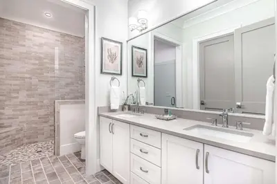 a white bathroom with two sinks and a toilet at Paradise Found 30A in Seacrest
