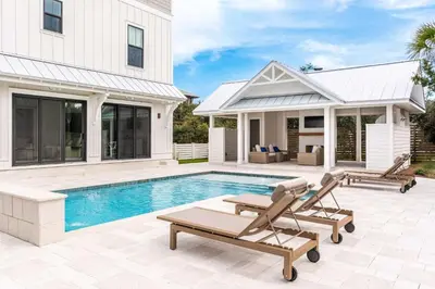 a swimming pool with two lounge chairs and a house at Paradise Found 30A in Seacrest