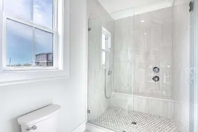 a bathroom with a shower with a toilet and a window at Paradise Found 30A in Seacrest