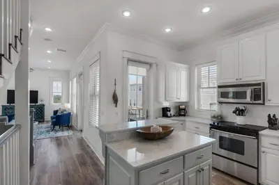 a kitchen with white cabinets and a large island at The Yellow Rose in Santa Rosa Beach