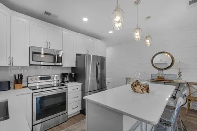a kitchen with white cabinets and a counter top at Feeling Tip Sea in Santa Rosa Beach