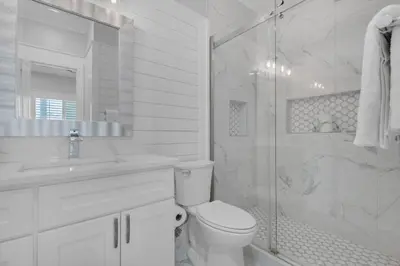 a white bathroom with a toilet and a shower at Feeling Tip Sea in Santa Rosa Beach