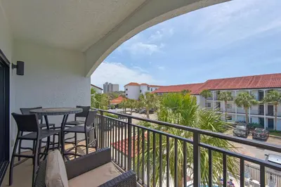a balcony with chairs and tables and a view of a city at Feeling Tip Sea in Santa Rosa Beach