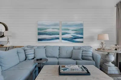 a living room with a blue couch and a table at Feeling Tip Sea in Santa Rosa Beach
