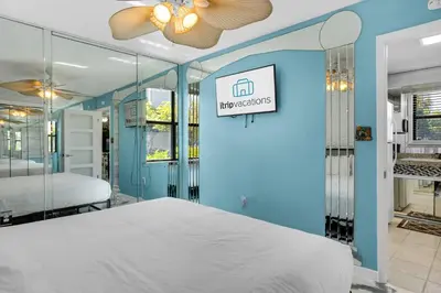 a bedroom with a bed and a blue wall at Beachwood Villas 7G in Santa Rosa Beach