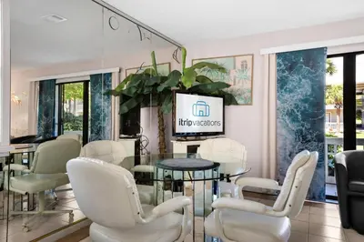 a dining room with white chairs and a glass table at Beachwood Villas 7G in Santa Rosa Beach