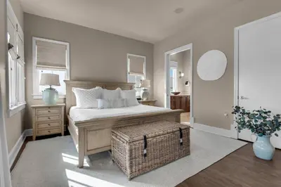 a bedroom with a bed and a wicker stool in it at The Penthouse at Seagrove in Santa Rosa Beach