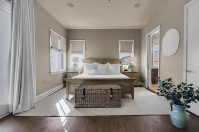 a bedroom with a bed and a table and windows at The Penthouse at Seagrove in Santa Rosa Beach