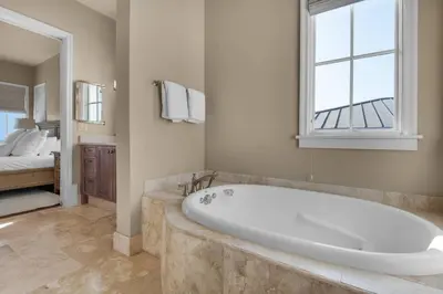 a large bath tub in a bathroom with a bedroom at The Penthouse at Seagrove in Santa Rosa Beach