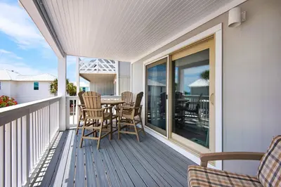 a porch with a table and chairs on a balcony at Cloud Nine By the Sea in Inlet Beach