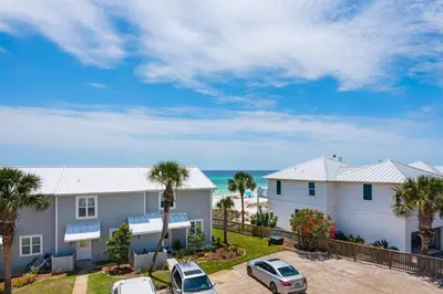 a house with two cars parked in a parking lot at Cloud Nine By the Sea in Inlet Beach