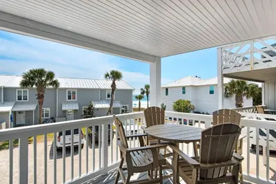 a patio with a table and chairs on a balcony at Cloud Nine By the Sea in Inlet Beach
