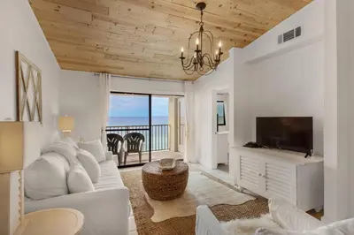a living room with a white couch and a television at Beachside 10 in Santa Rosa Beach