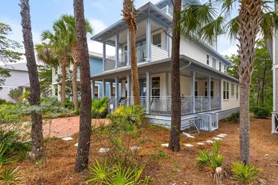 a house with palm trees in front of it at Palms and Pines in Rosemary Beach
