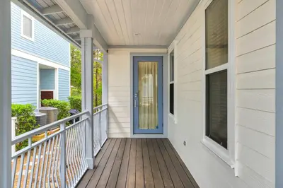 a front porch of a home with a blue door at Palms and Pines in Rosemary Beach