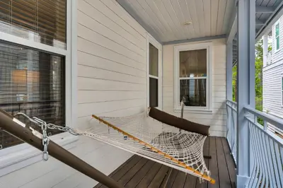 a hammock on the porch of a house at Palms and Pines in Rosemary Beach