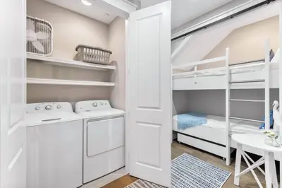 a small white room with bunk beds and a table at Saltwater Sanctuary in Santa Rosa Beach