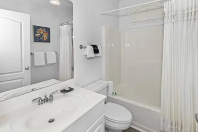 a white bathroom with a sink and a toilet at Monterey B-102 in Seacrest