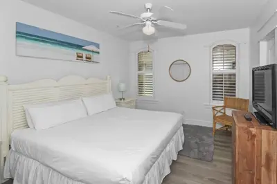 a bedroom with a white bed and a television at Monterey B-102 in Seacrest