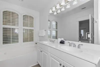a white bathroom with two sinks and a mirror at Monterey B-102 in Seacrest