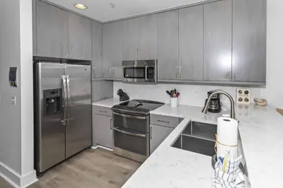 a kitchen with stainless steel appliances and gray cabinets at Monterey B-102 in Seacrest