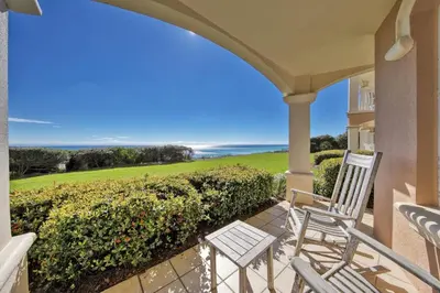 a porch with two chairs and a view of the ocean at Monterey B-102 in Seacrest