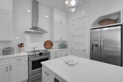 a kitchen with white cabinets and a stainless steel refrigerator at La Dolce Beacha in Inlet Beach
