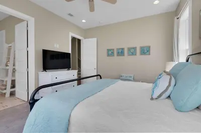 a bedroom with a large bed with a television at La Dolce Beacha in Inlet Beach