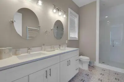 a bathroom with two sinks and a mirror and a toilet at La Dolce Beacha in Inlet Beach