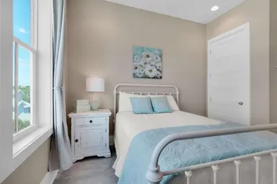 a small bedroom with a bed and a window at La Dolce Beacha in Inlet Beach