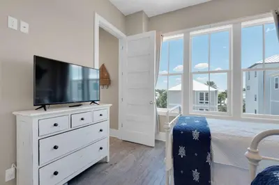a bedroom with a flat screen tv on a dresser at La Dolce Beacha in Inlet Beach