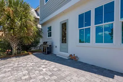 a white house with a palm tree in front of it at La Dolce Beacha in Inlet Beach