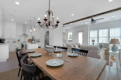 a kitchen and living room with a wooden table and chairs at La Dolce Beacha in Inlet Beach