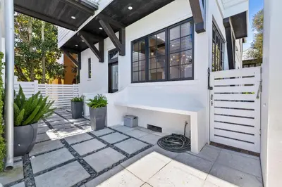 a white house with a fireplace in a courtyard at Abba Cottage in Rosemary Beach