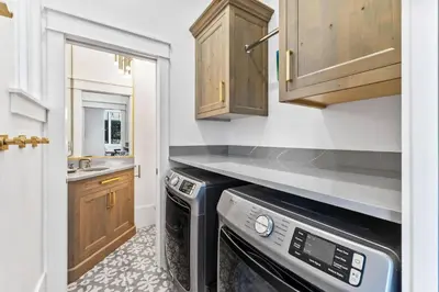 a kitchen with a black dishwasher and wooden cabinets at Abba Cottage in Rosemary Beach