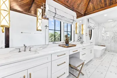 a bathroom with white counters and a wooden ceiling at Abba Cottage & Carriage House in Rosemary Beach