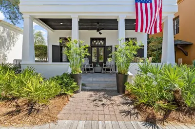 a home with an american flag on the front porch at Abba Cottage & Carriage House in Rosemary Beach
