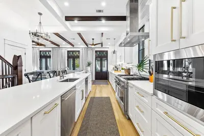 a large kitchen with white cabinets and appliances at Abba Cottage & Carriage House in Rosemary Beach