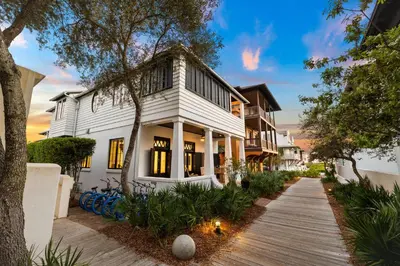 a white house with a wooden walkway at Abba Cottage & Carriage House in Rosemary Beach