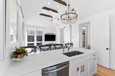 a white kitchen with a sink and a counter at Abba Carriage House in Rosemary Beach