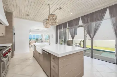 a kitchen with white countertops and large windows at Devonshire West in Seacrest